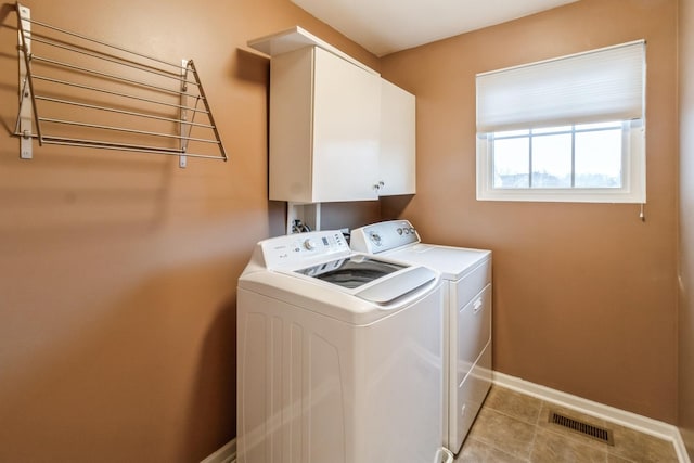 laundry area with cabinets, light tile patterned flooring, and separate washer and dryer