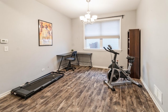 workout room with an inviting chandelier and dark wood-type flooring