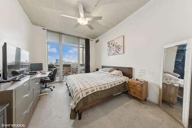 bedroom featuring ceiling fan, light colored carpet, access to exterior, and a wall of windows