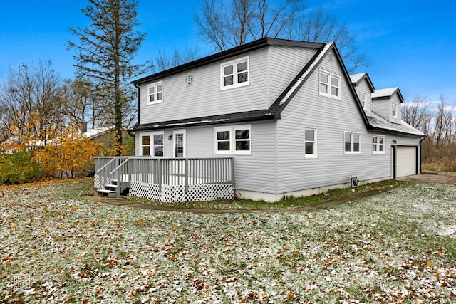 rear view of house featuring a garage and a wooden deck