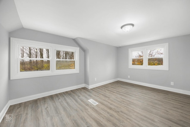 bonus room featuring lofted ceiling and light hardwood / wood-style flooring