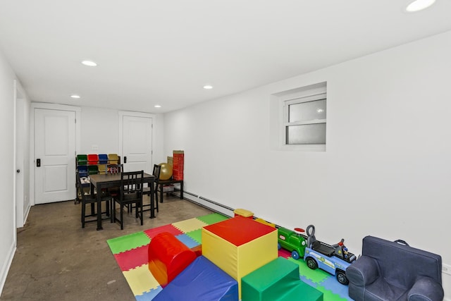 playroom featuring a baseboard heating unit and concrete floors