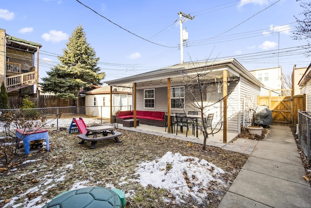 snow covered house with an outdoor hangout area and a patio area