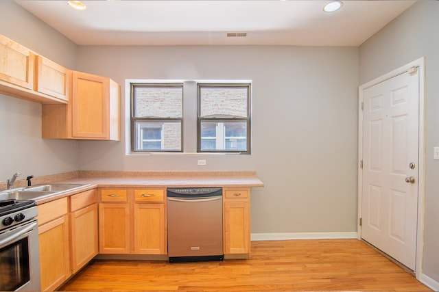 kitchen featuring stainless steel appliances, light brown cabinets, and light hardwood / wood-style floors