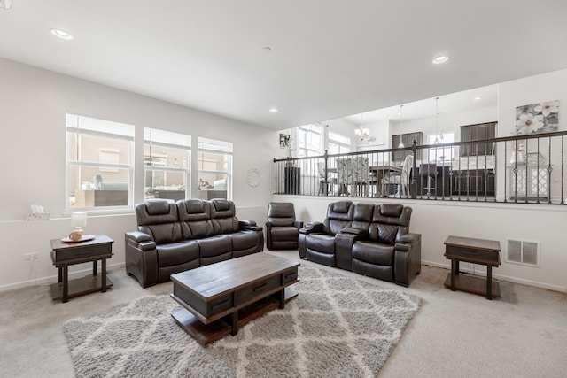 carpeted living room featuring a notable chandelier and plenty of natural light