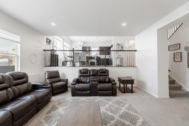 carpeted living room featuring an inviting chandelier