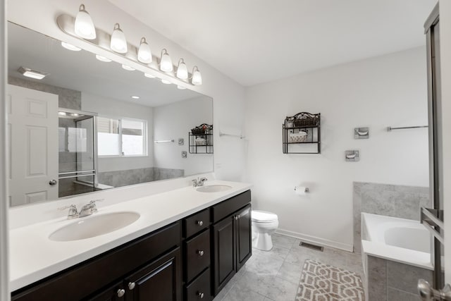 bathroom with vanity, tiled bath, and toilet