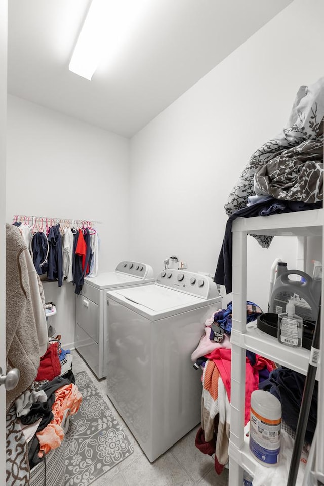 laundry room with washer and dryer and light tile patterned floors