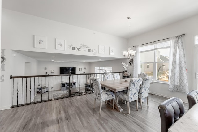 dining room with hardwood / wood-style flooring and an inviting chandelier