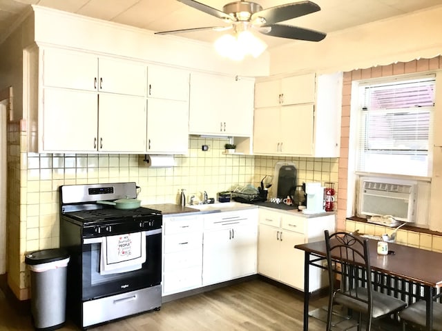 kitchen featuring white cabinetry, gas range, sink, and tasteful backsplash