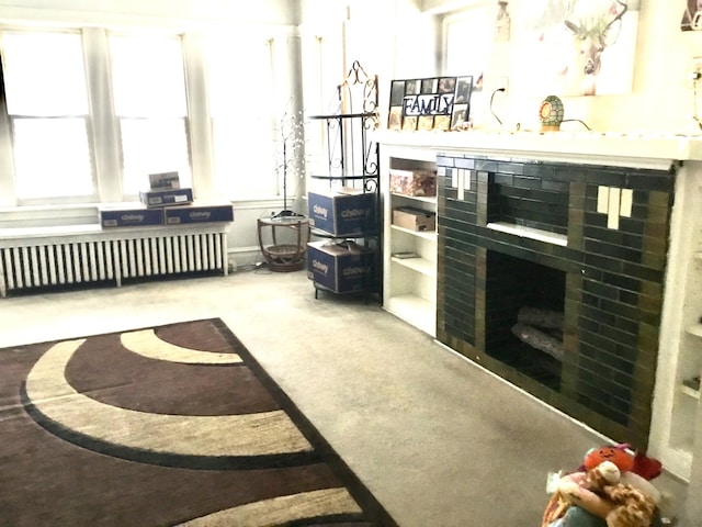 interior space with radiator heating unit, a fireplace, and carpet floors