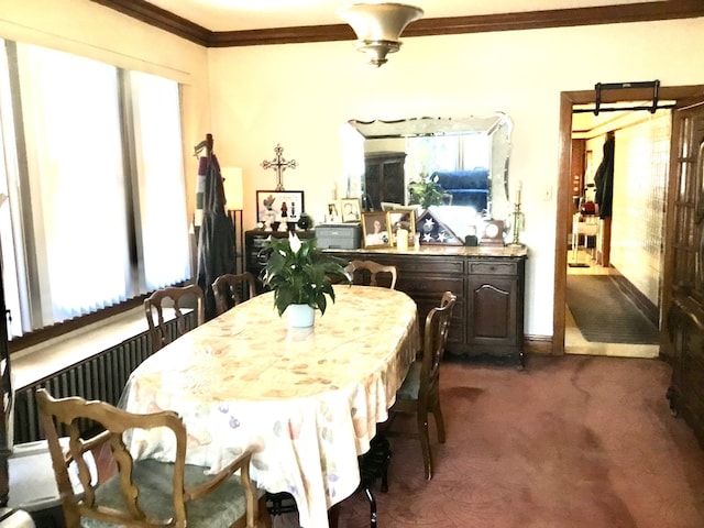 dining area featuring a wealth of natural light, ornamental molding, and dark colored carpet