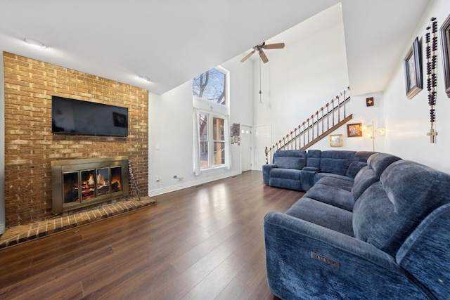 living room with ceiling fan, a fireplace, and dark hardwood / wood-style flooring