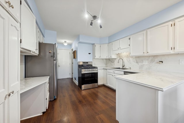 kitchen featuring sink, dark wood-type flooring, stainless steel appliances, tasteful backsplash, and white cabinets