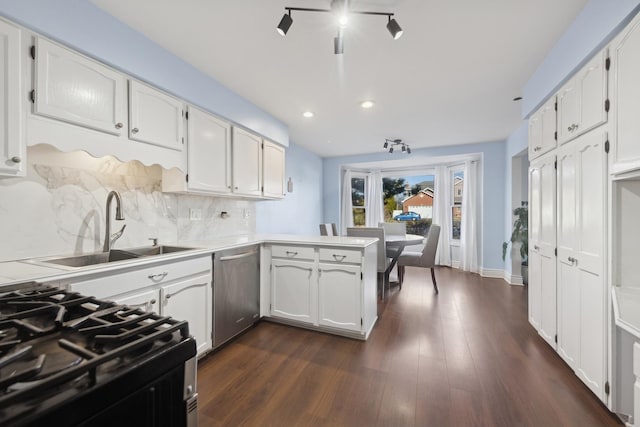 kitchen with white cabinetry, stainless steel dishwasher, kitchen peninsula, black gas range, and decorative backsplash