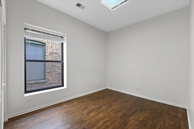 unfurnished room featuring dark hardwood / wood-style flooring and a skylight