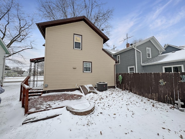 snow covered house featuring central air condition unit