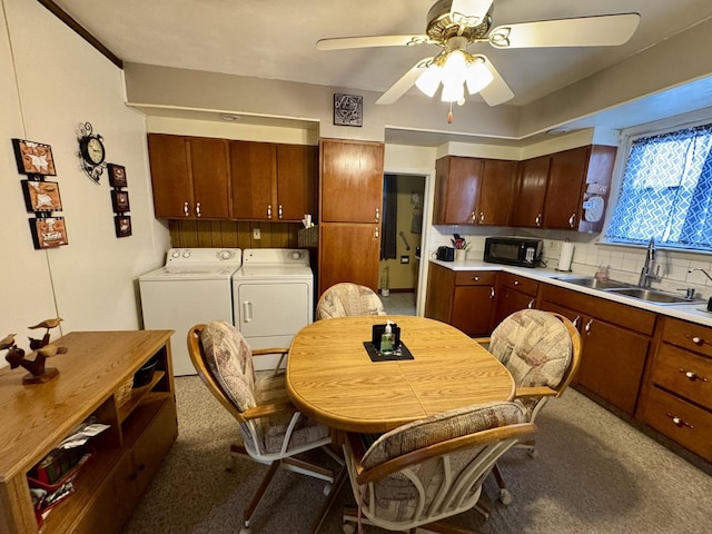 kitchen featuring sink, ceiling fan, backsplash, carpet flooring, and separate washer and dryer