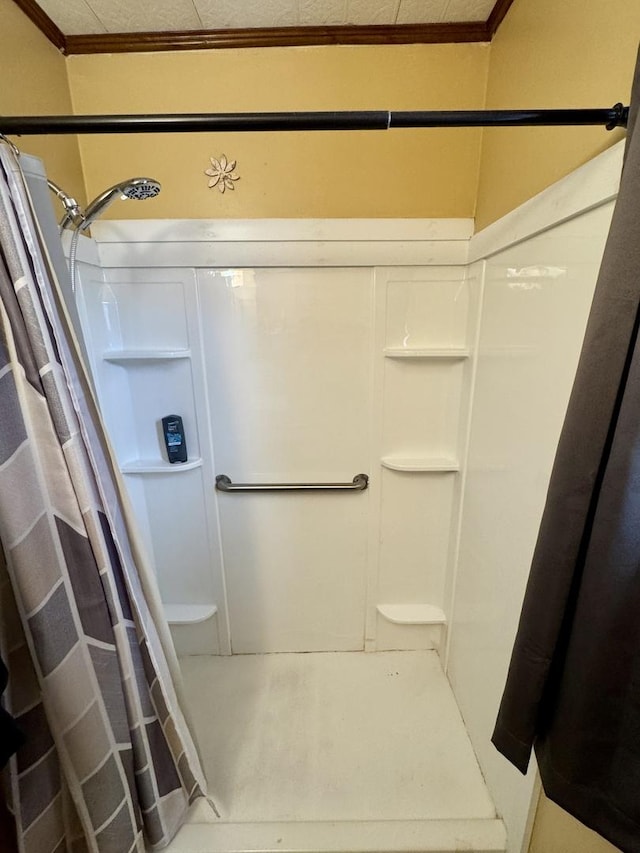 bathroom featuring ornamental molding and walk in shower