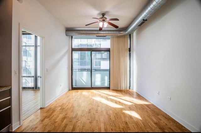 empty room with ceiling fan and light wood-type flooring