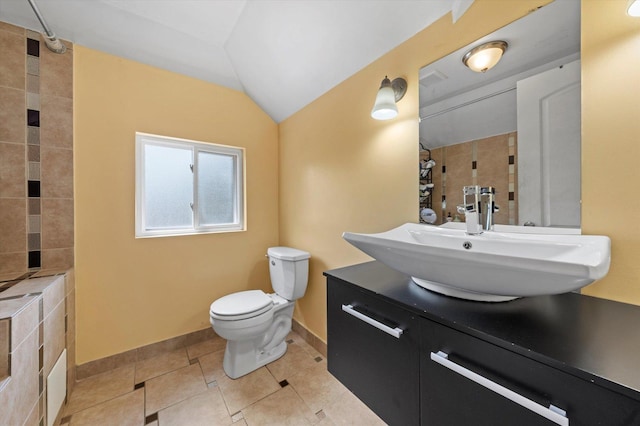 bathroom with tile patterned floors, lofted ceiling, toilet, and vanity