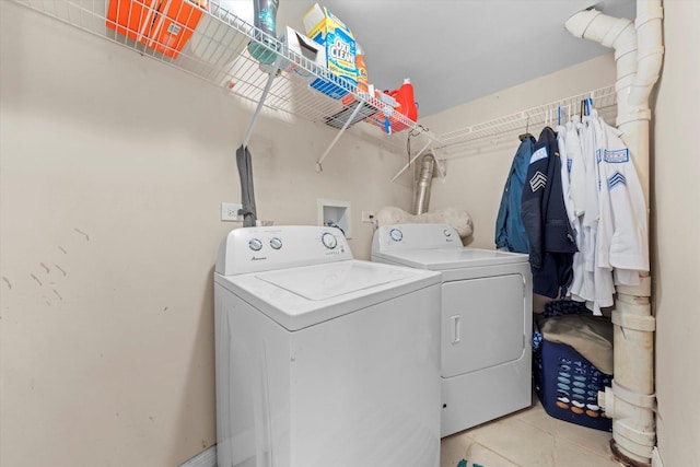 clothes washing area featuring washing machine and clothes dryer and light tile patterned floors