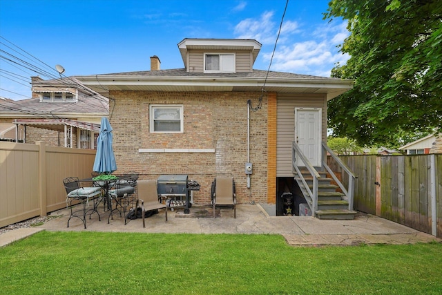 rear view of property with a patio and a lawn