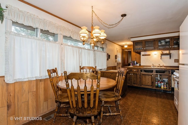 dining space with ornamental molding and an inviting chandelier