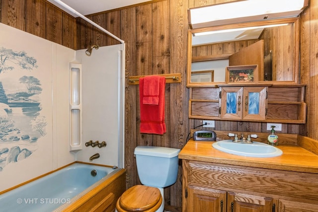 full bathroom with wooden walls, shower / tub combination, vanity, and toilet