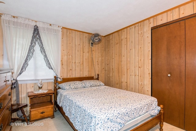 carpeted bedroom with a closet and wood walls