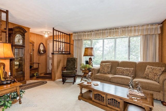 carpeted living room featuring wood walls