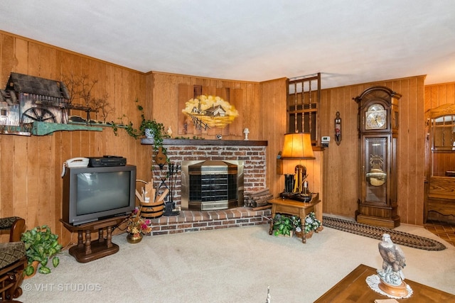 living room with a brick fireplace, wood walls, and carpet