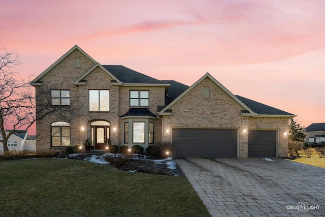 view of front of home with a garage and a yard