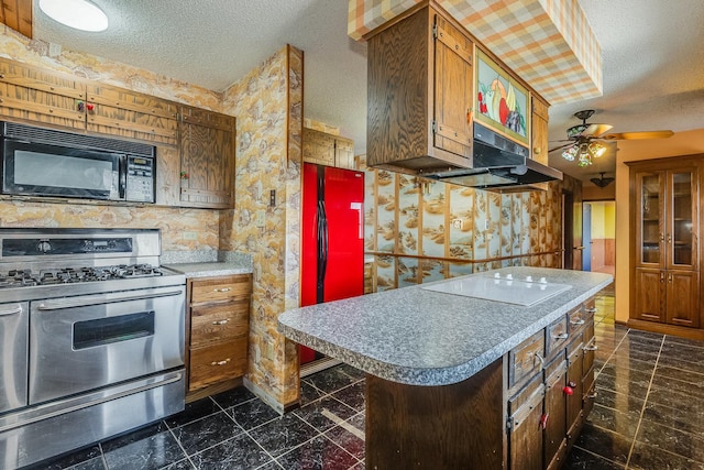 kitchen with ceiling fan, stainless steel gas stove, fridge, a textured ceiling, and white electric stovetop