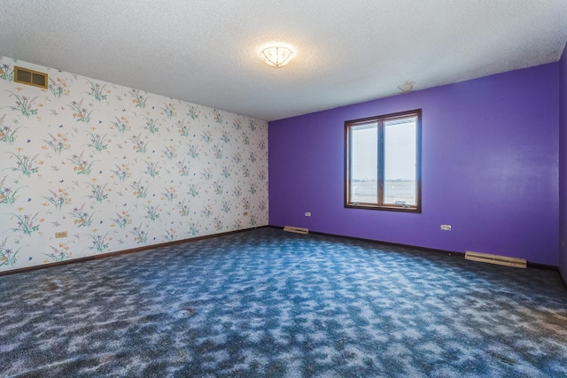 unfurnished room featuring a textured ceiling and dark colored carpet