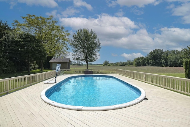 view of pool featuring a storage shed and a deck