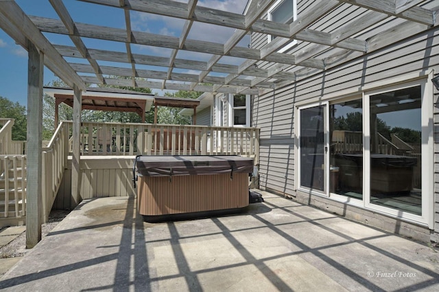 view of patio / terrace featuring a wooden deck, a hot tub, and a pergola