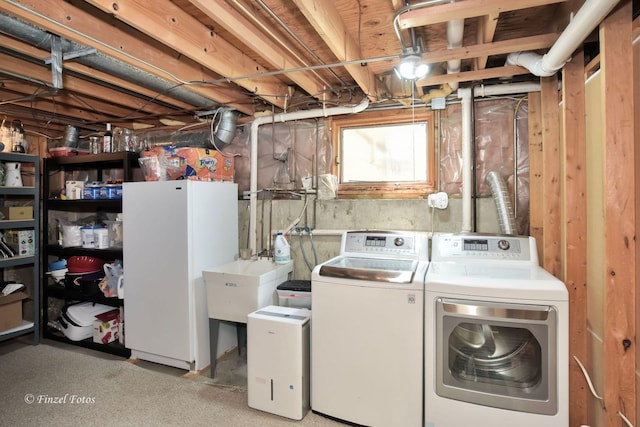 laundry area with separate washer and dryer and sink