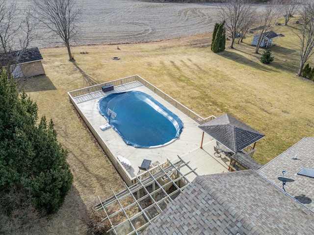 view of pool featuring a rural view, a storage shed, and a gazebo