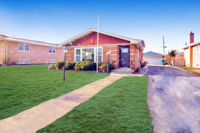 view of front of property with a garage, an outdoor structure, and a front lawn