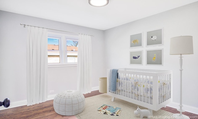 bedroom with a nursery area and wood-type flooring