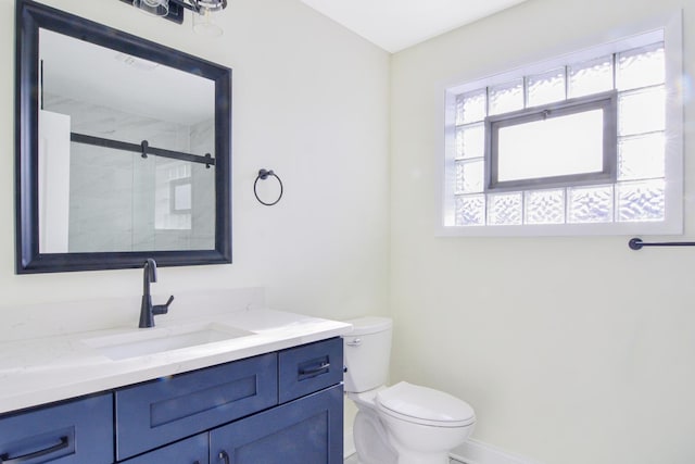 bathroom featuring vanity, toilet, and a shower with shower door