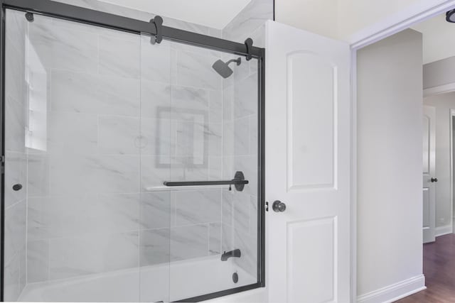 bathroom with shower / bath combination with glass door and hardwood / wood-style floors