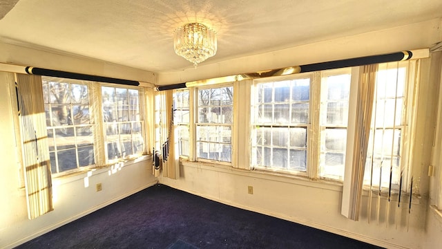 unfurnished sunroom with a healthy amount of sunlight and an inviting chandelier