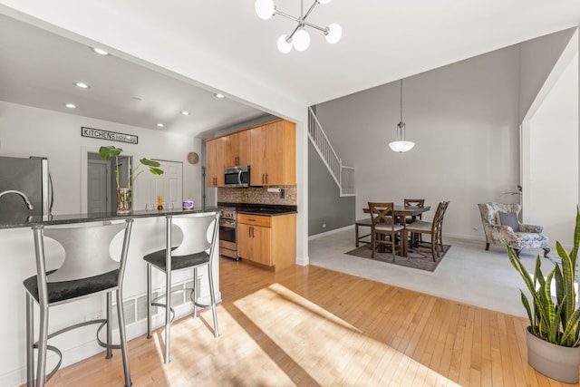 kitchen featuring pendant lighting, stainless steel appliances, dark countertops, tasteful backsplash, and modern cabinets