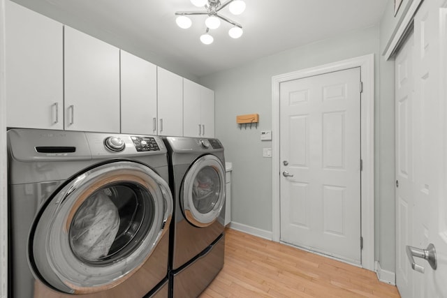 washroom featuring light wood-style floors, washer and dryer, cabinet space, and baseboards