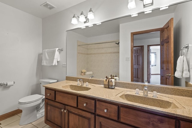 bathroom with tile patterned flooring, vanity, and toilet