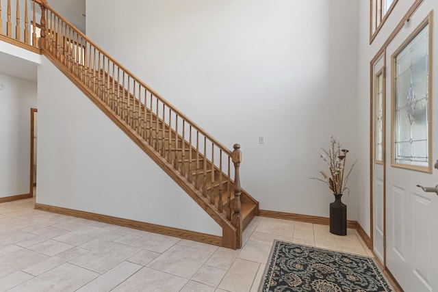 entryway featuring a high ceiling and light tile patterned floors