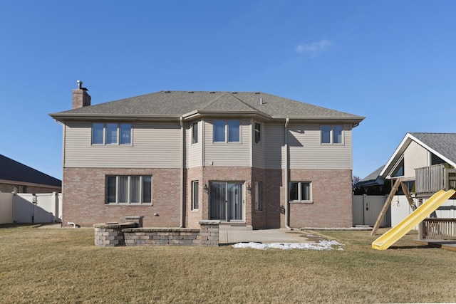 rear view of property featuring a playground, a patio, and a yard