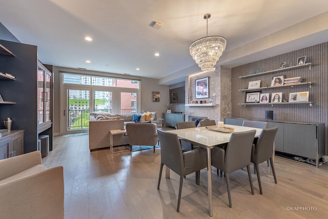 dining space with a notable chandelier and light wood-type flooring